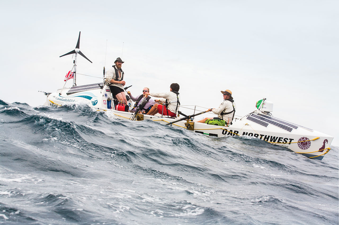 Four guys in a big rowboat on the open ocean